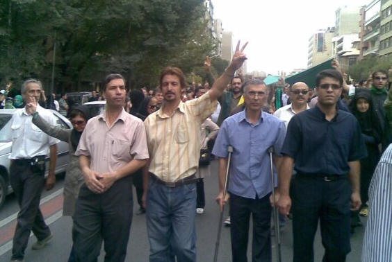 Heshmat Tabarzadi (center, with his hand raised)